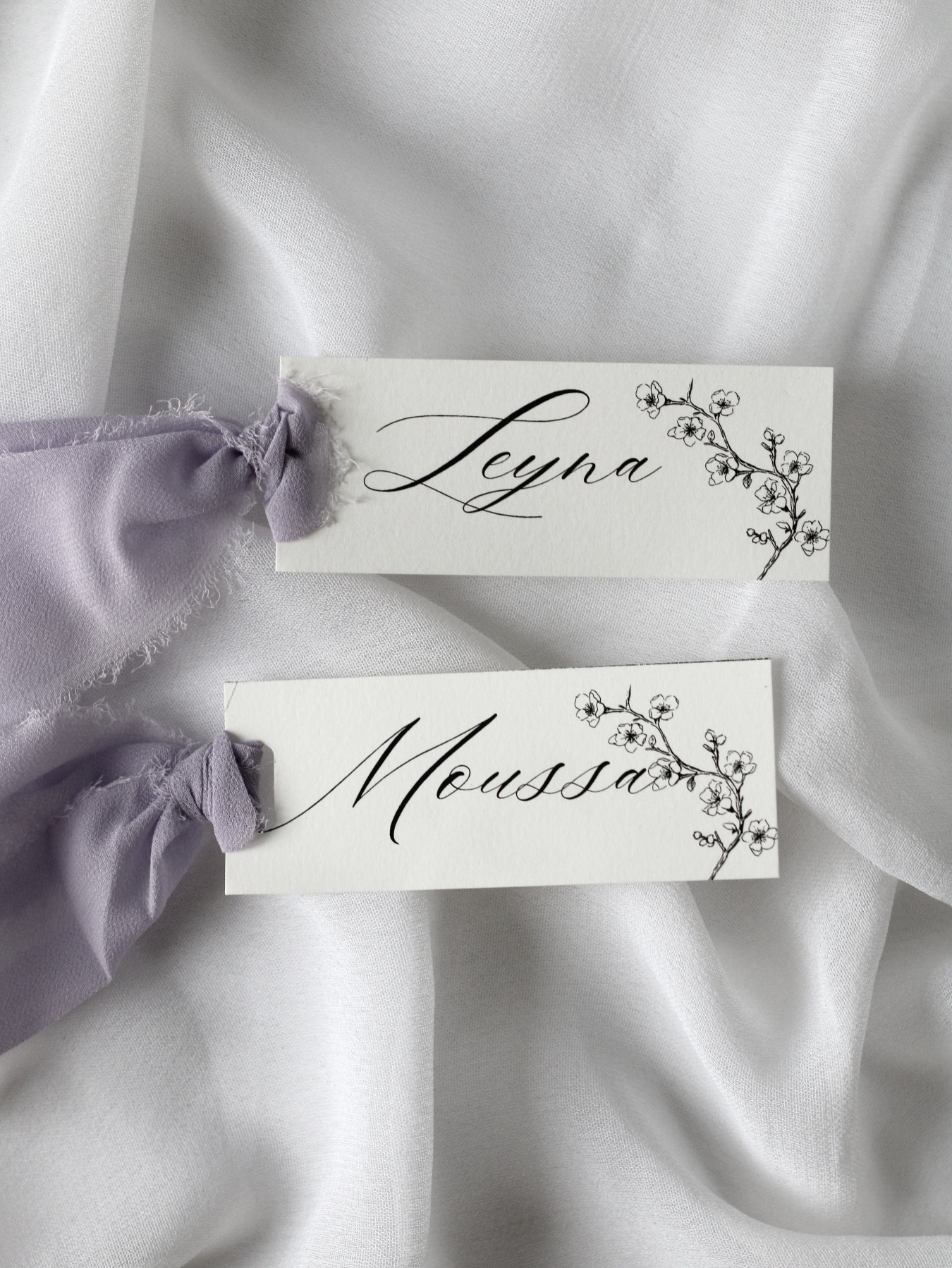 Marque-place de mariage personnalisé Collection COVEY au format 10 × 4 cm avec délicat motif de fleurs de cerisier, disponible avec ou sans ruban ou gland.