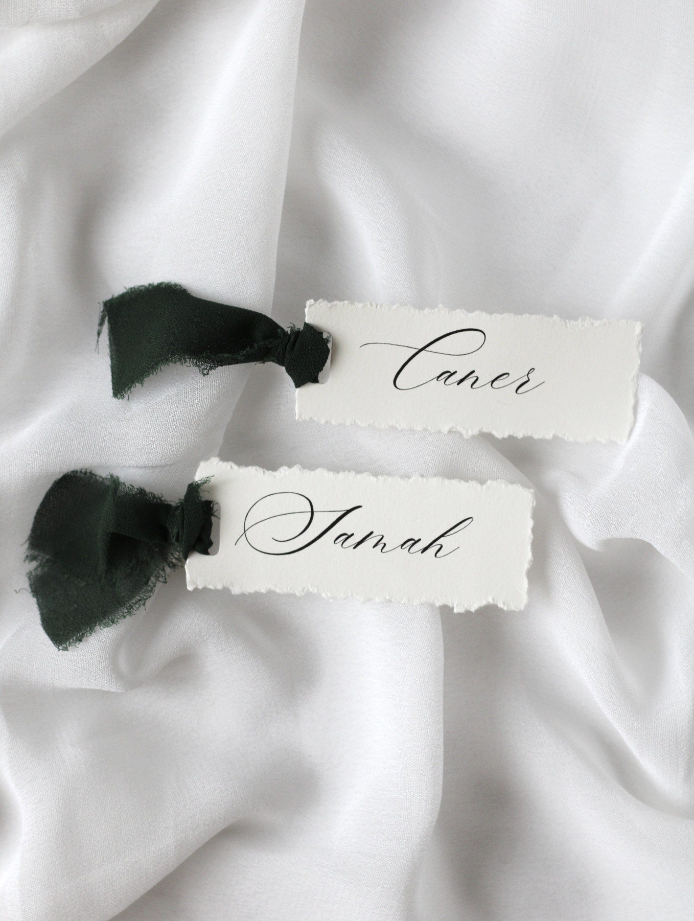 Marque-place de mariage personnalisé Collection NILUFER au format 10 × 4 cm avec élégante bordure effet déchiré, disponible avec ou sans ruban ou gland.