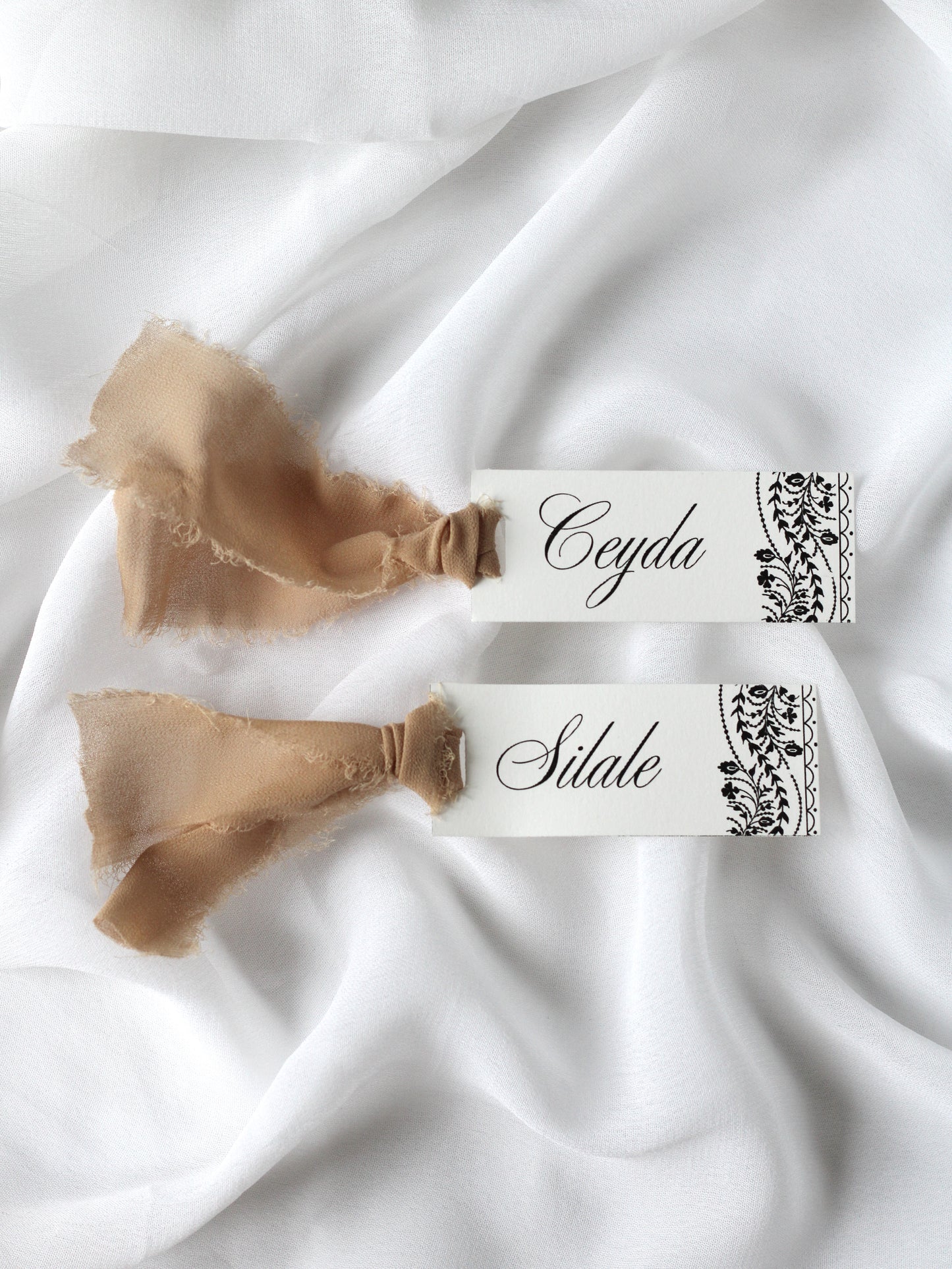 Marque-place de mariage personnalisé Collection OSMAN au format 10 × 4 cm avec le motif emblématique de la collection, disponible avec ou sans ruban ou gland.