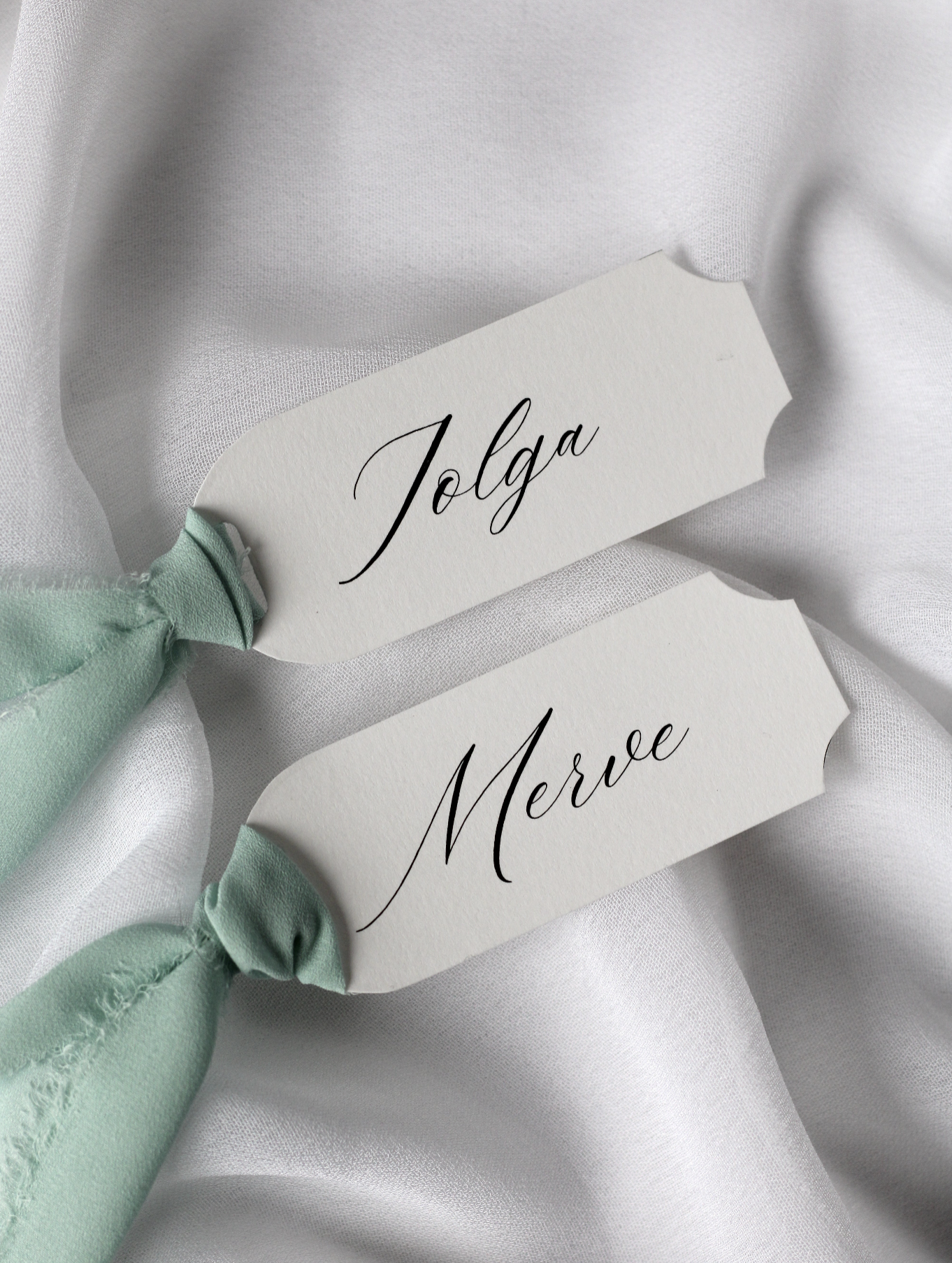 Marque-place de mariage personnalisé Collection PALAZZO au format 10 × 4 cm avec élégante découpe en arc sur les quatre coins, disponible avec ou sans ruban ou gland.