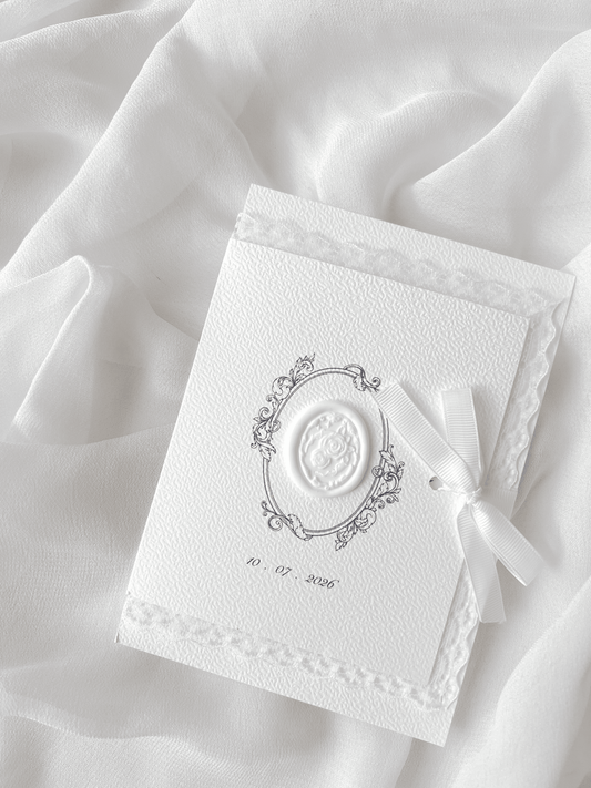 Faire-part de mariage personnalisé Collection ÉTERNELLE avec pochette blanche à contour dentelle, ruban personnalisé avec la date du mariage, monogramme et cachet de cire.