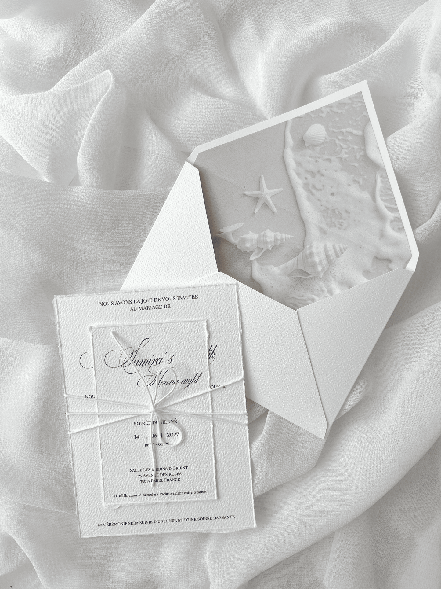Faire-part de mariage personnalisé Collection SHELL avec enveloppe blanche, liner intérieur motif coquillages et plage, invitation effet déchiré, corde blanche naturelle et carte RSVP assortie en option.