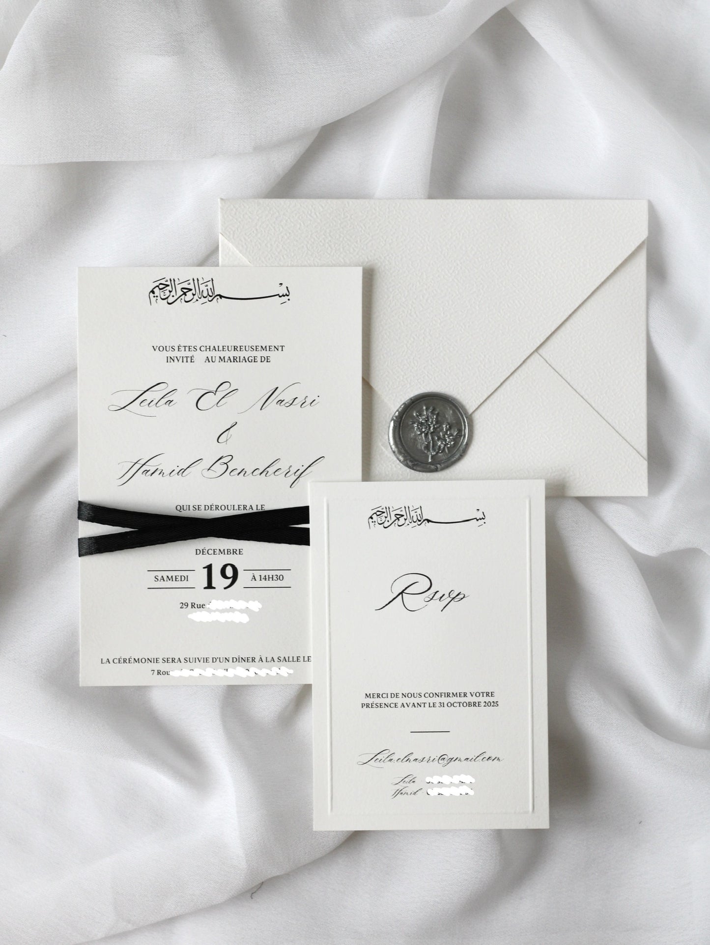 Faire-part de mariage personnalisé Collection SIGNATURE avec enveloppe blanche, cachet de cire, invitation ornée d'un ruban noir croisé et carte RSVP à contour embossé en option.