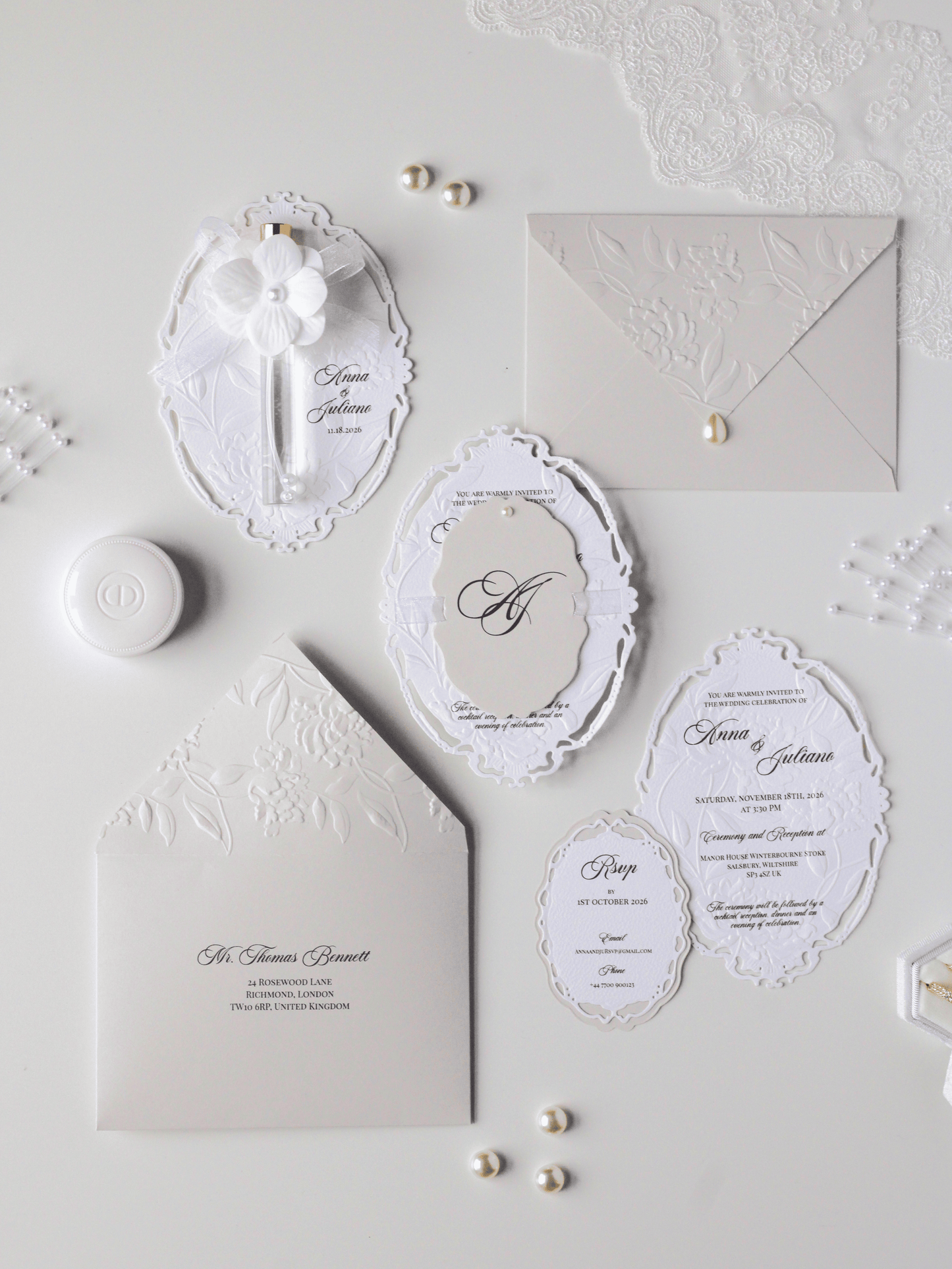 Faire-part de mariage personnalisé Collection WINDSOR avec enveloppe grège, embossage floral, découpe ovale ajourée, ruban organza, perle décorative et carte RSVP assortie.