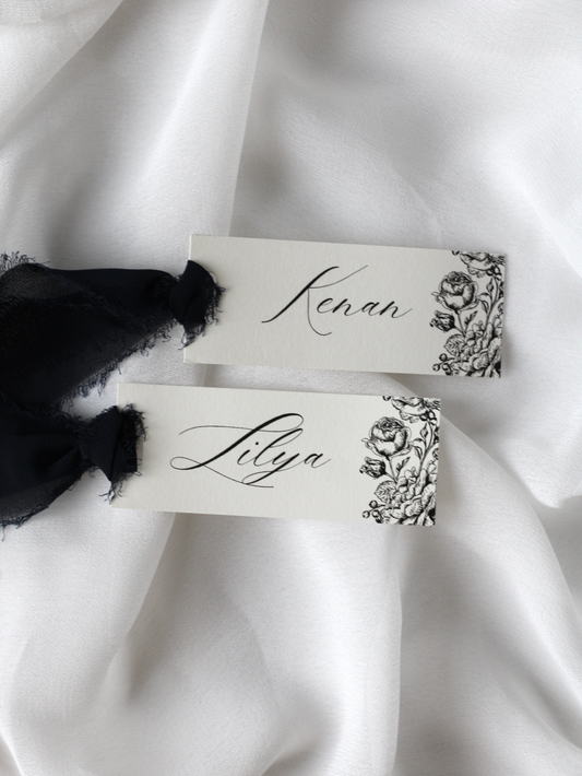Marque-place de mariage personnalisé Collection CAMELIA au format 10 × 4 cm avec délicat motif de fleurs de camélia, disponible avec ou sans ruban ou gland.