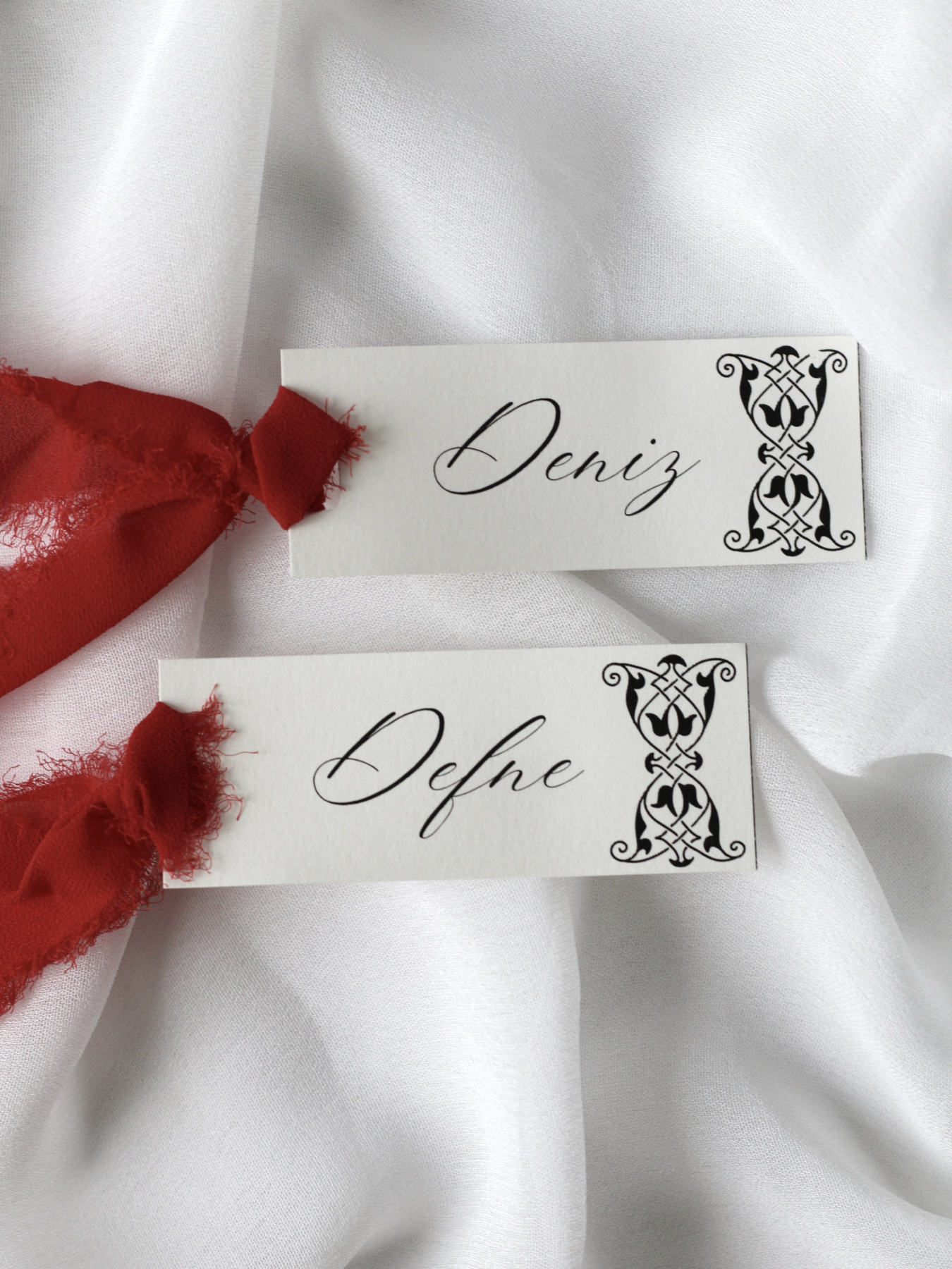 Marque-place de mariage personnalisé Collection CHARLOTTE au format 10 × 4 cm avec élégant motif décoratif sur le bord, disponible avec ou sans ruban ou gland.