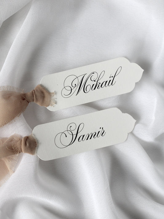 Marque-place de mariage personnalisé Collection EID au format 10 × 4 cm avec découpe orientale (Die Cut), disponible avec ou sans ruban ou gland.