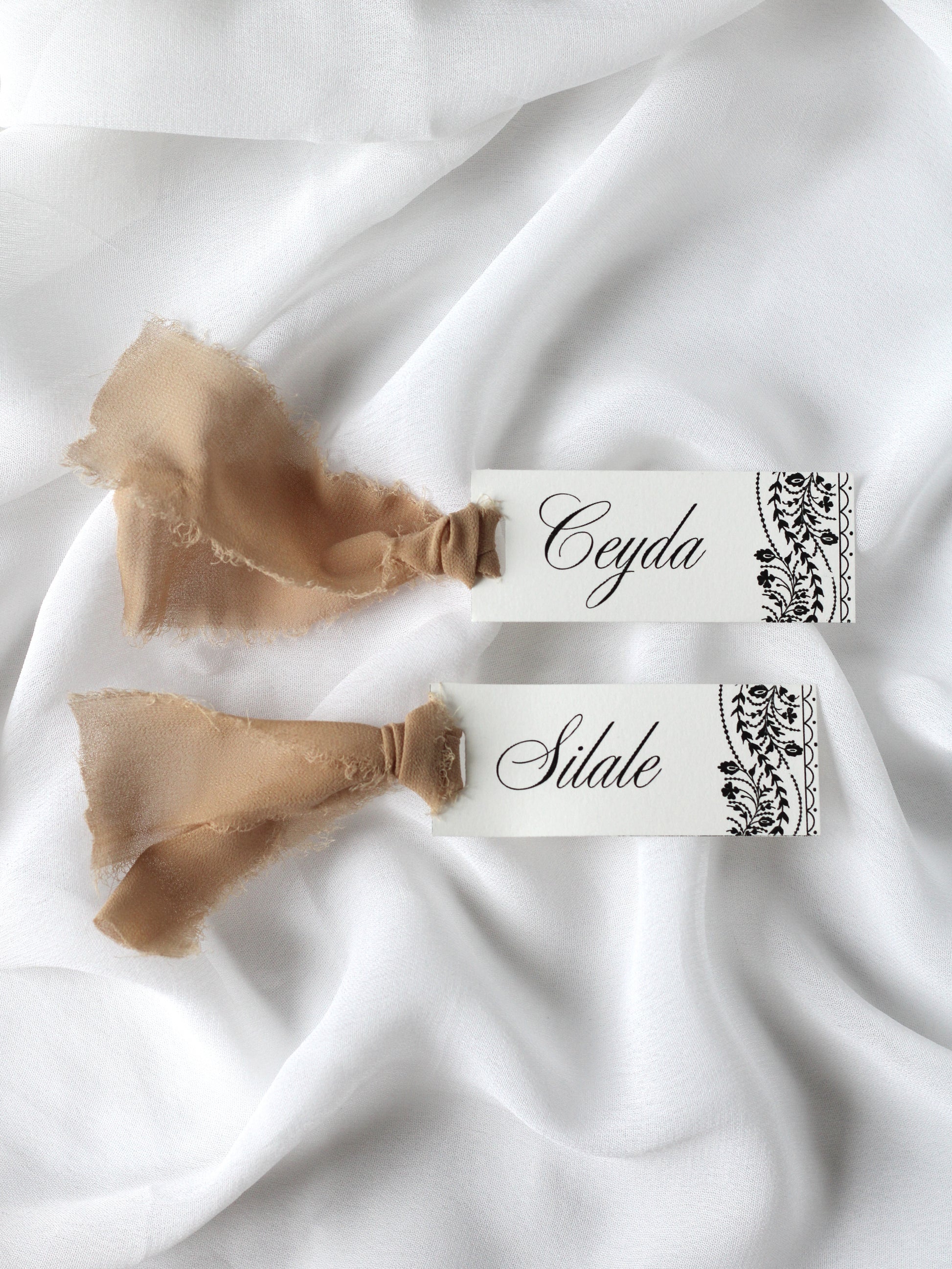 Marque-place de mariage personnalisé Collection OSMAN au format 10 × 4 cm avec le motif emblématique de la collection, disponible avec ou sans ruban ou gland.