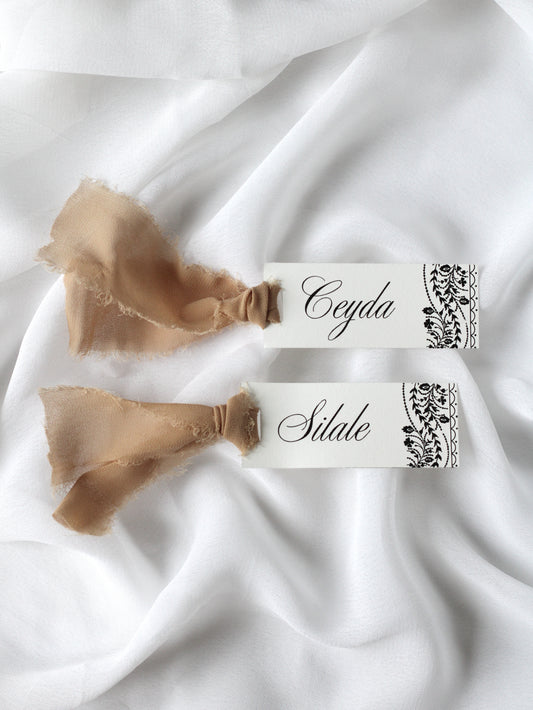 Marque-place de mariage personnalisé Collection OSMAN au format 10 × 4 cm avec le motif emblématique de la collection, disponible avec ou sans ruban ou gland.
