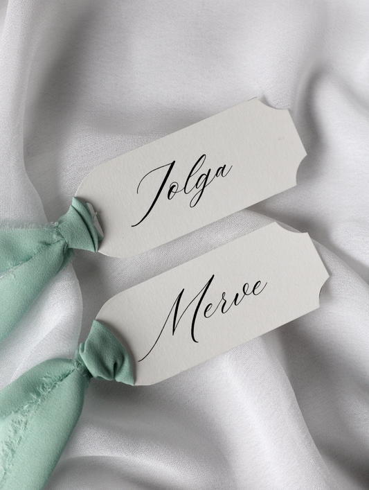 Marque-place de mariage personnalisé Collection PALAZZO au format 10 × 4 cm avec élégante découpe en arc sur les quatre coins, disponible avec ou sans ruban ou gland.