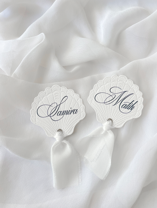 Marque-place de mariage personnalisé Collection SHELL I en forme de coquillage avec découpe Die-Cut et prénom imprimé, disponible avec ou sans ruban ou gland.
