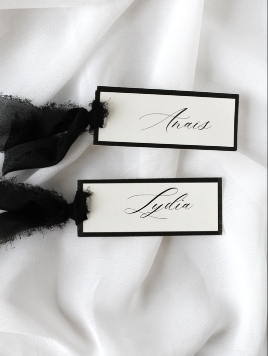 Marque-place de mariage personnalisé Collection SIGNATURE au format 10 × 4 cm avec élégante bordure noire, disponible avec ou sans ruban ou gland.