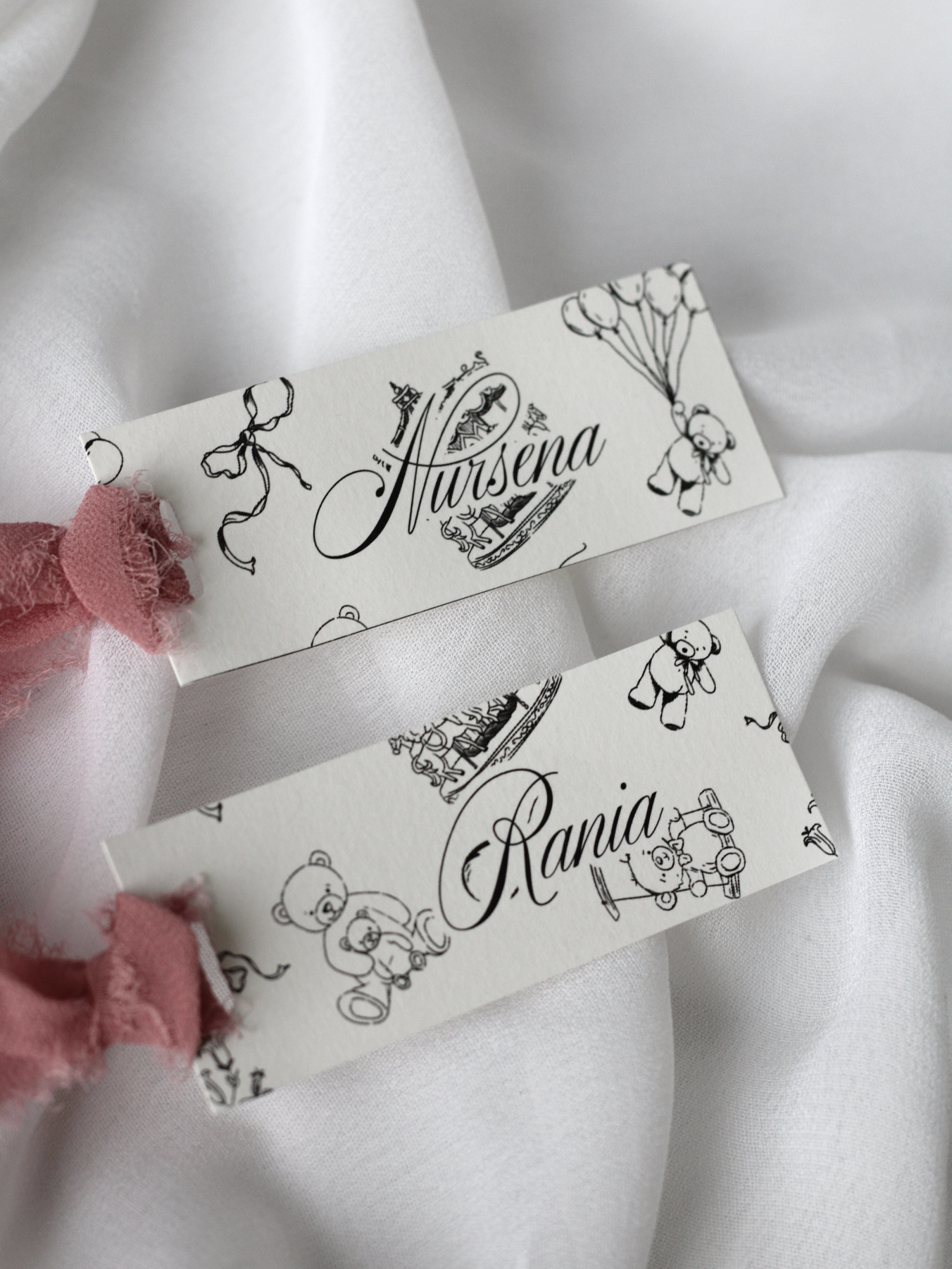 Marque-place personnalisé Collection MÉLODIE au format 10 × 4 cm avec adorable motif enfant, disponible avec ou sans ruban ou gland.