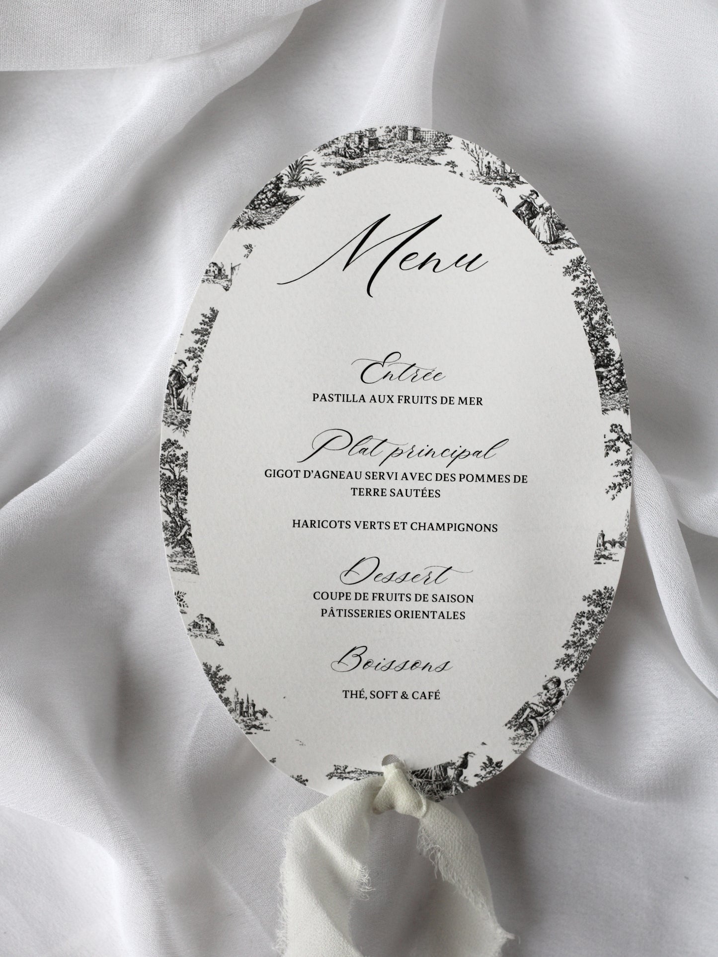 Menu de mariage personnalisé Collection VERSAILLES au format ovale avec motif Toile de Jouy et finition ruban en mousseline blanc.